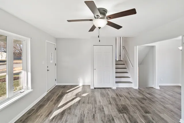 a view of a livingroom with stairs and wooden floor