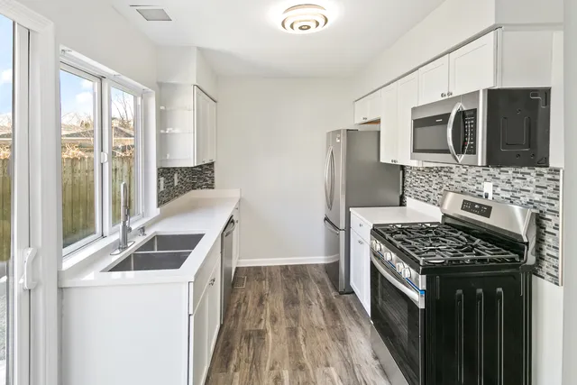 a kitchen that has a sink and a stove top oven