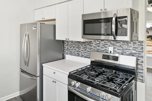 a kitchen with stainless steel appliances granite countertop a stove a refrigerator and a sink