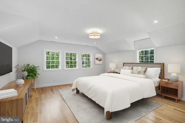 an empty room with wooden floor ceiling fan and windows
