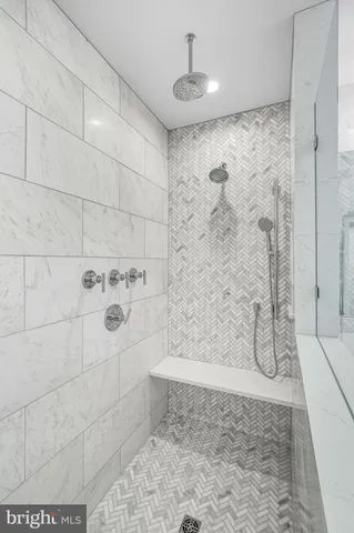 an empty room with wooden floor windows and fan