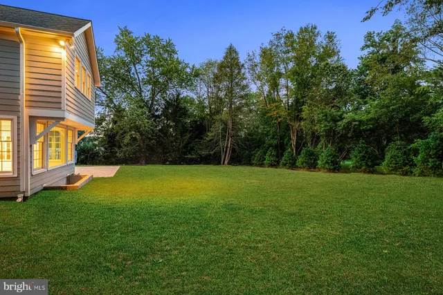 a front view of a house with a garden and trees