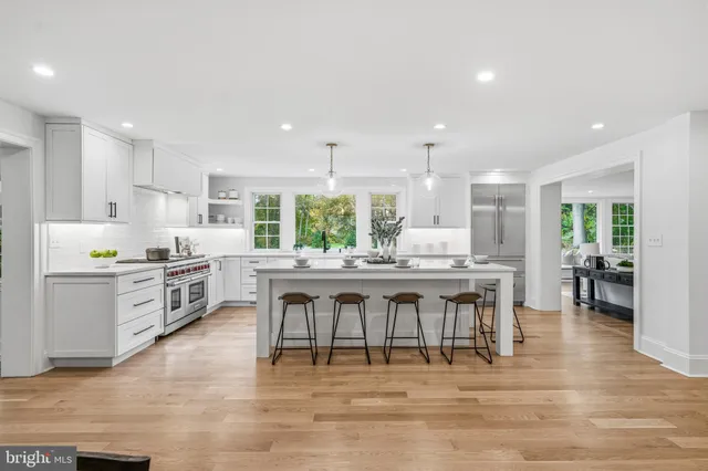 a kitchen with white cabinets appliances and wooden floor