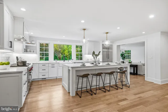 a kitchen with stove a sink dishwasher and white cabinets with wooden floor