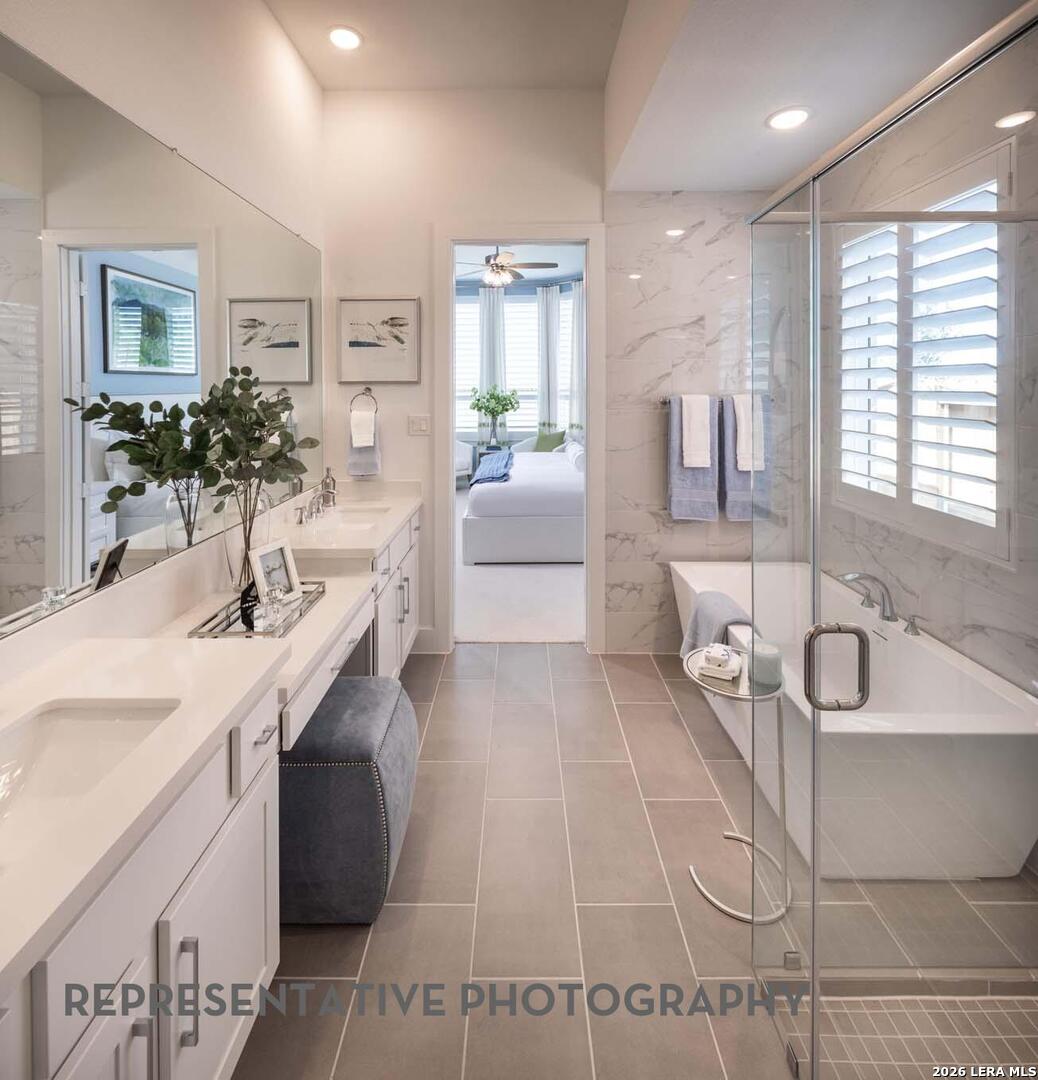 237 Boulder Creek Boerne, TX 78006 - Photo 18 of 32 a bathroom with a sink a large mirror and a bathtub