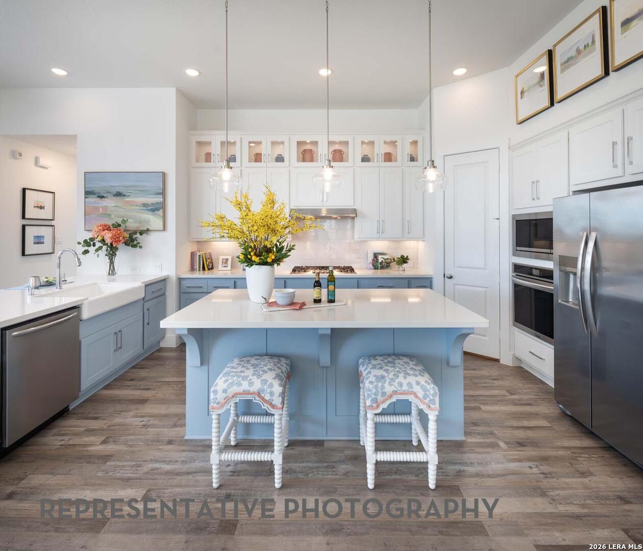 237 Boulder Creek Boerne, TX 78006 - Photo 2 of 32 a kitchen with stainless steel appliances granite countertop a table chairs sink refrigerator and microwave