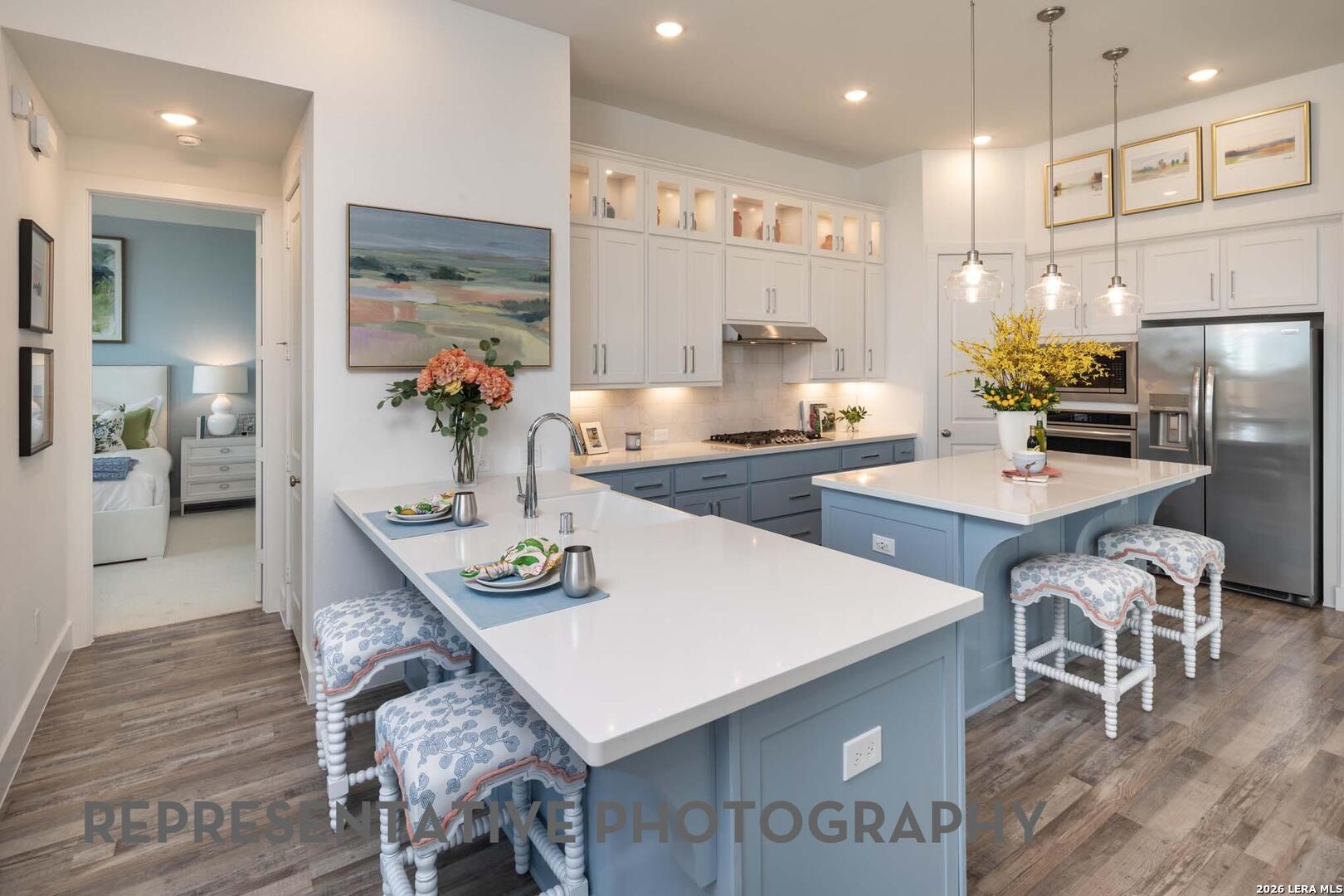 237 Boulder Creek Boerne, TX 78006 - Photo 5 of 32 a large kitchen with kitchen island a dining table and chairs