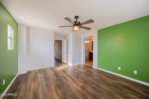 a view of a room with a ceiling fan and hardwood floor