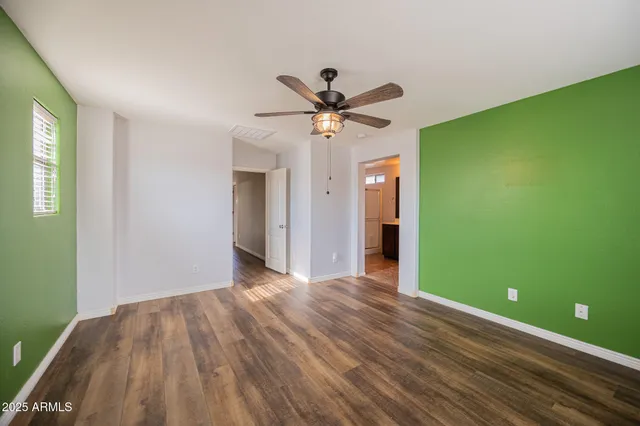 a view of a room with a ceiling fan and hardwood floor