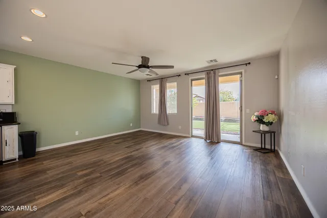 a view of an empty room with a window and wooden floor