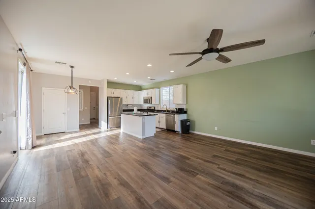 a view of kitchen with granite countertop cabinets and refrigerator