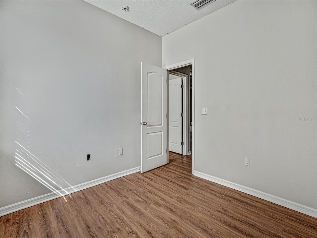 11713 Colony Lakes Boulevard New Port Richey, FL 34654 - Photo 24 of 38 a view of an empty room with wooden floor