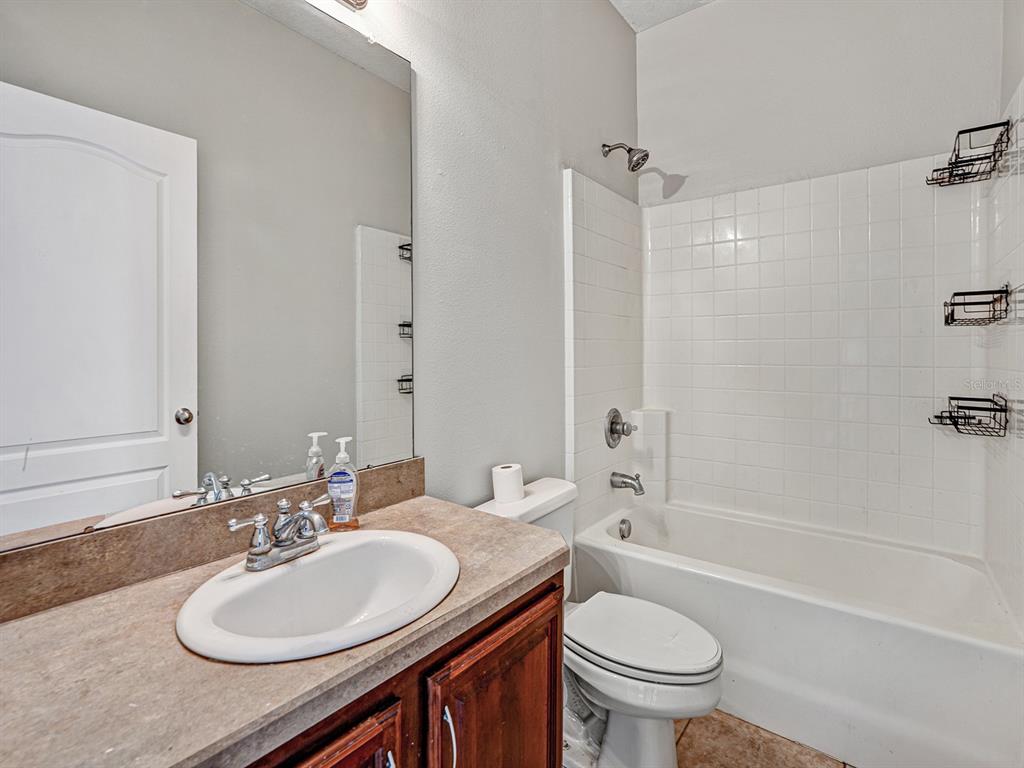11713 Colony Lakes Boulevard New Port Richey, FL 34654 - Photo 28 of 38 a bathroom with a sink a toilet and shower