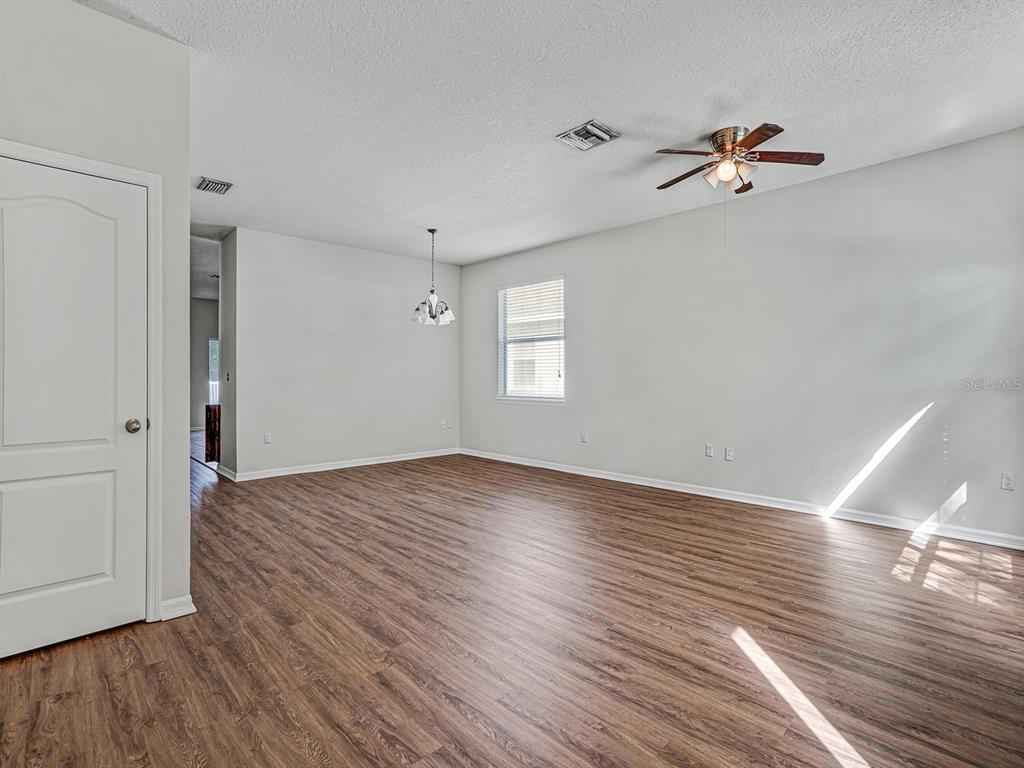 11713 Colony Lakes Boulevard New Port Richey, FL 34654 - Photo 4 of 38 a view of empty room with wooden floor and fan