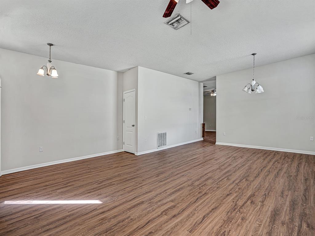 11713 Colony Lakes Boulevard New Port Richey, FL 34654 - Photo 5 of 38 a view of empty room with wooden floor and ceiling fan