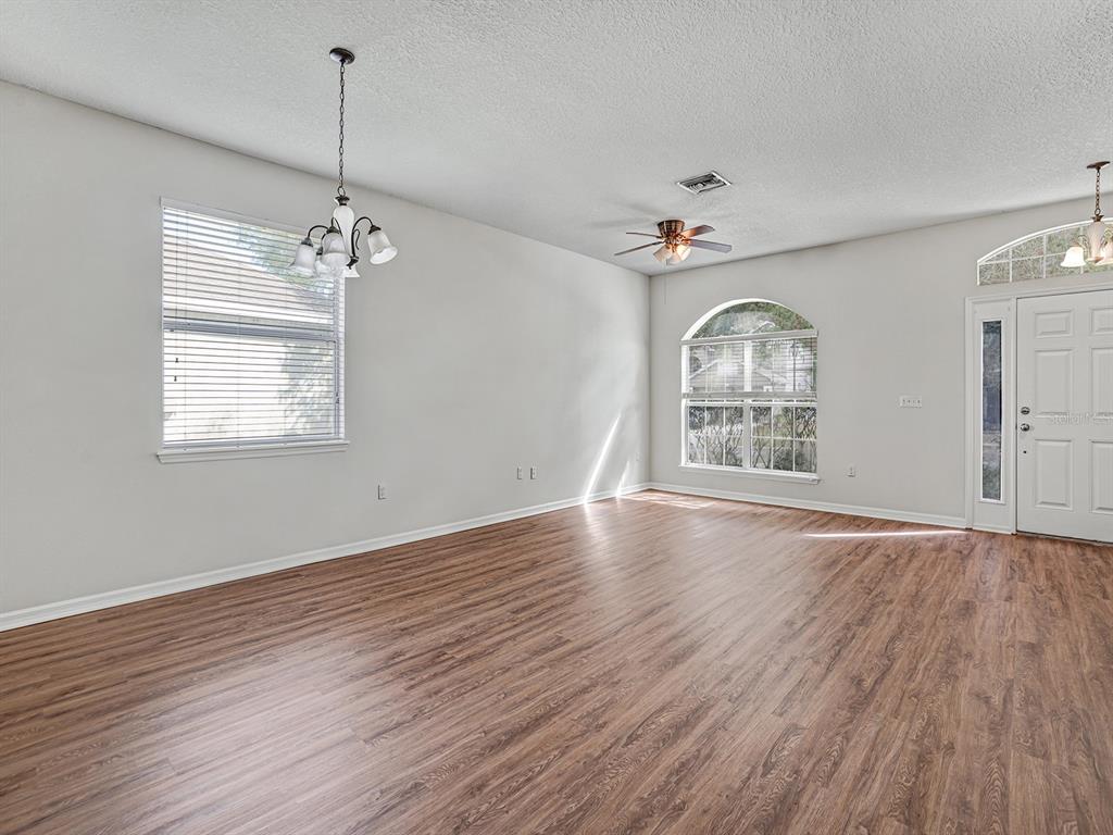 11713 Colony Lakes Boulevard New Port Richey, FL 34654 - Photo 7 of 38 a view of an empty room with wooden floor and a window