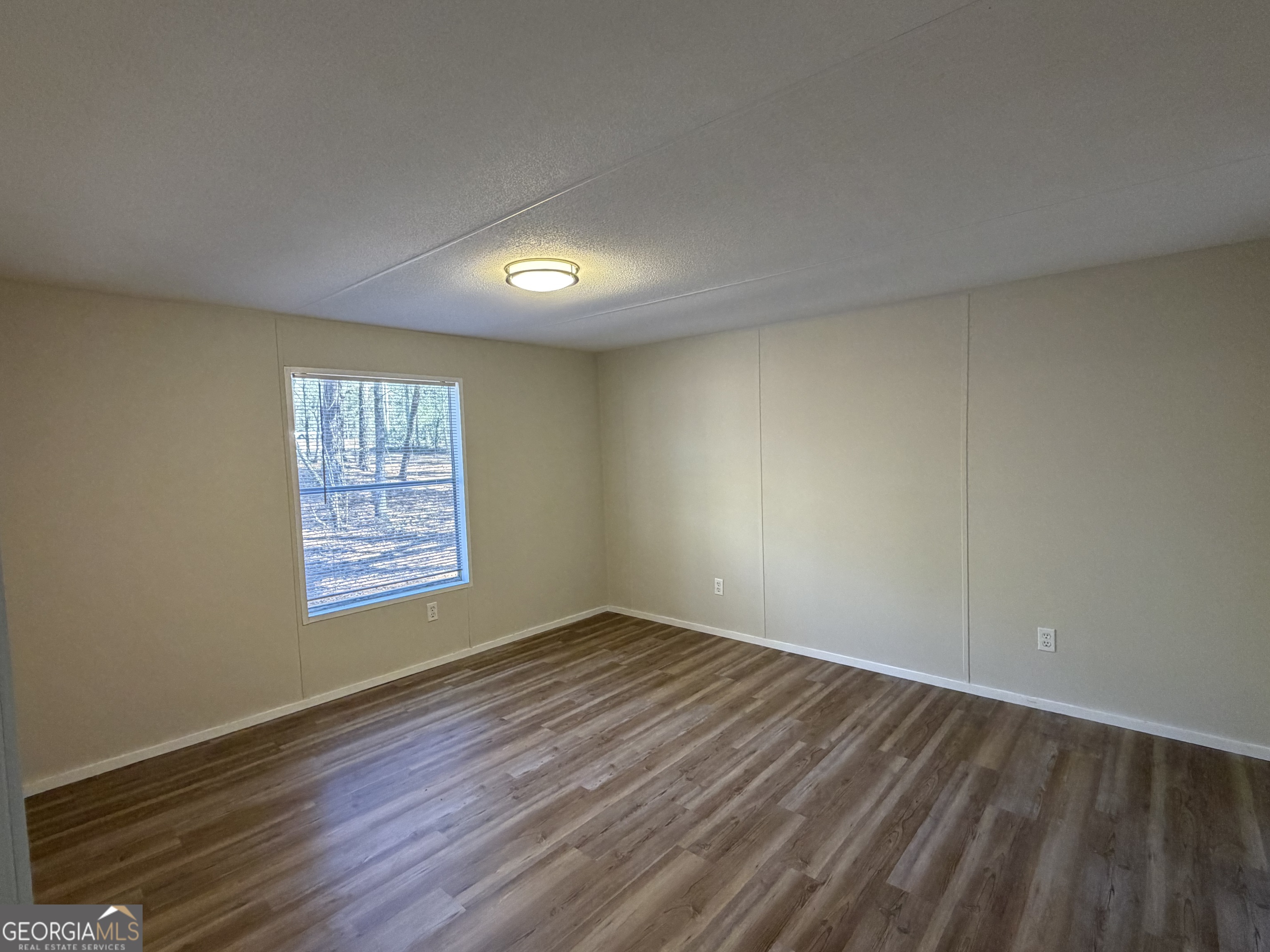 927 Louis Road Rentz, GA 31075 - Photo 13 of 22 an empty room with wooden floor and windows