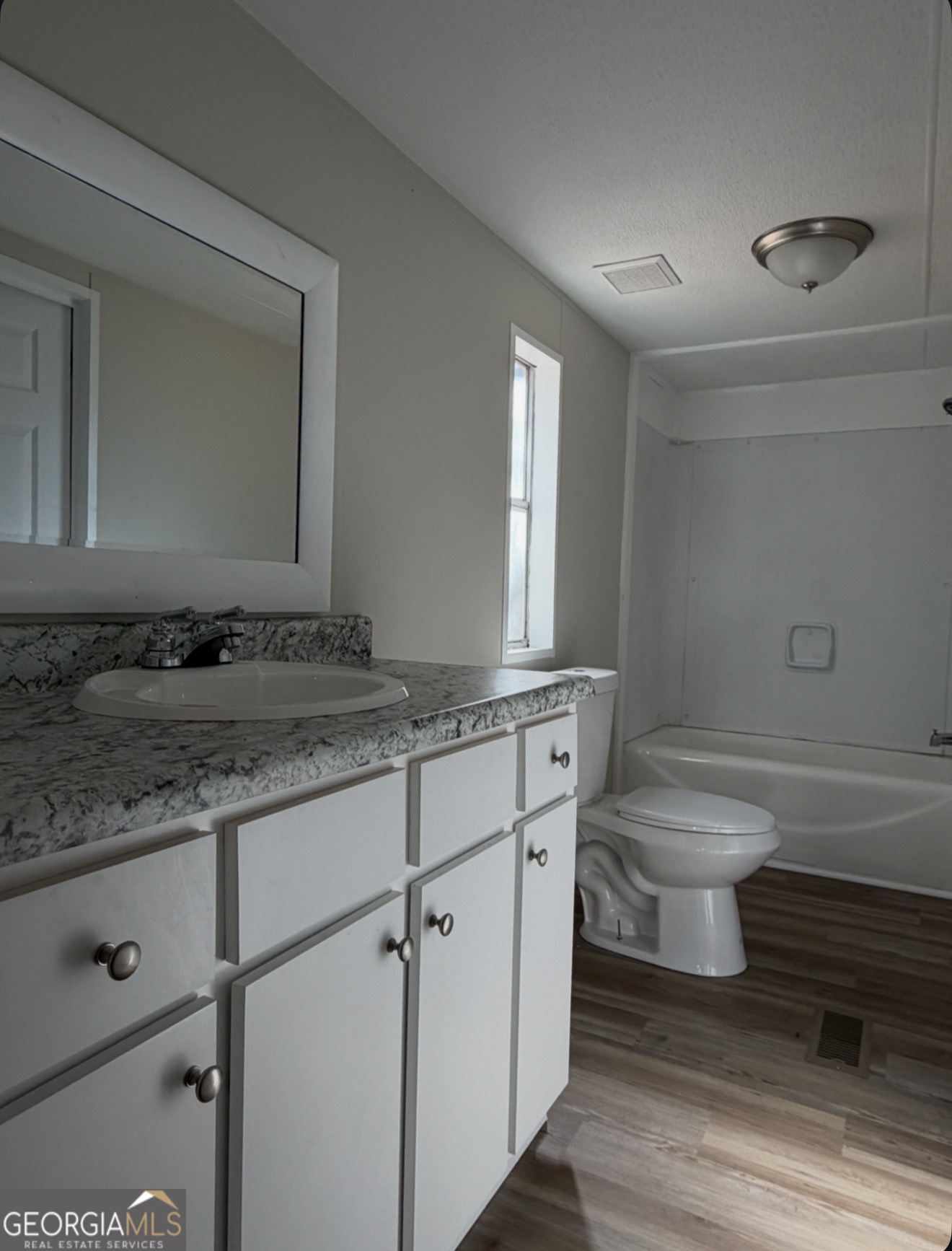 927 Louis Road Rentz, GA 31075 - Photo 16 of 22 a bathroom with a granite countertop toilet sink and mirror