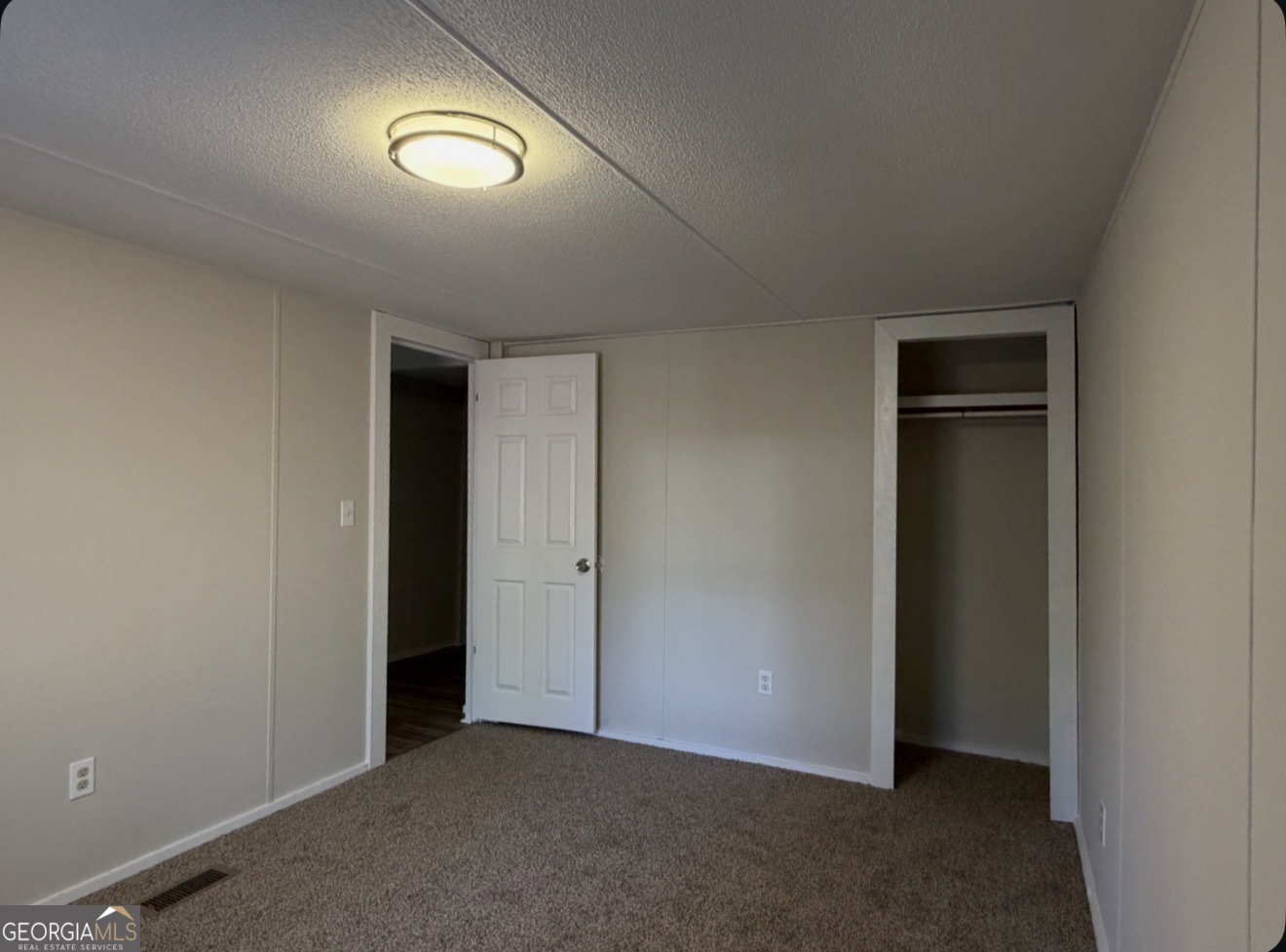 927 Louis Road Rentz, GA 31075 - Photo 17 of 22 an empty room with closet and wooden floor