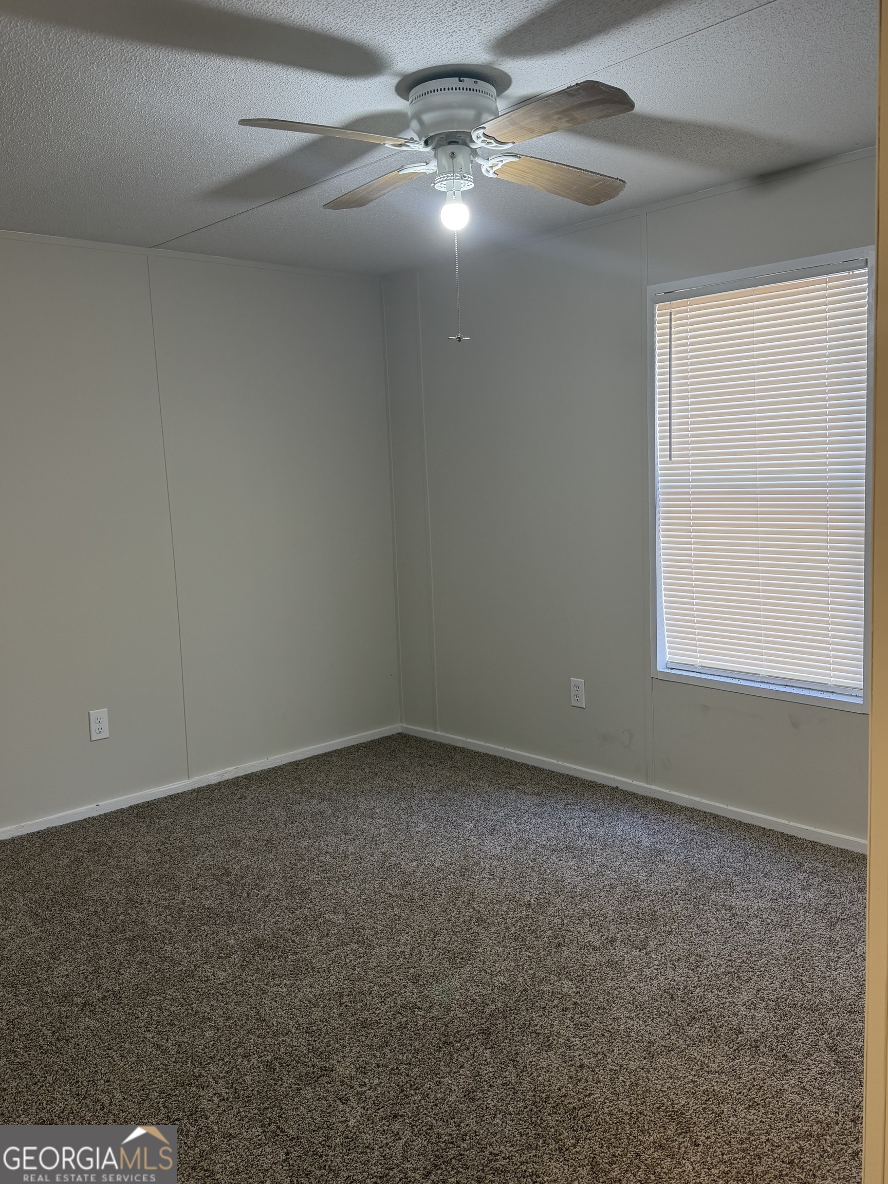 927 Louis Road Rentz, GA 31075 - Photo 18 of 22 an empty room with a ceiling fan and window