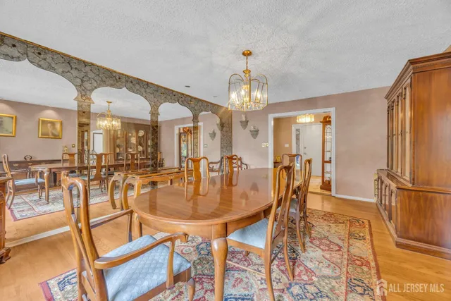 a dining room with furniture a chandelier and wooden floor