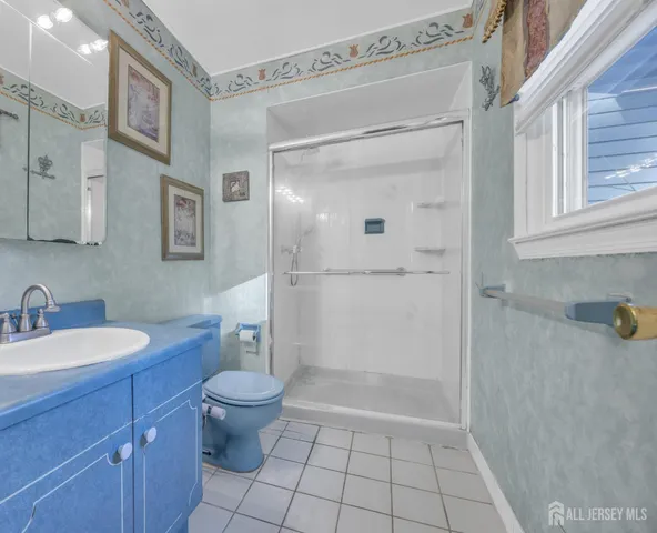 a bathroom with a granite countertop sink a toilet and a mirror