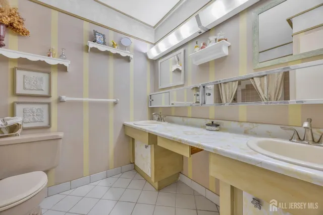 a bathroom with a granite countertop sink a toilet and a mirror