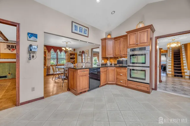 a view of kitchen with stainless steel appliances granite countertop a refrigerator and a stove top oven