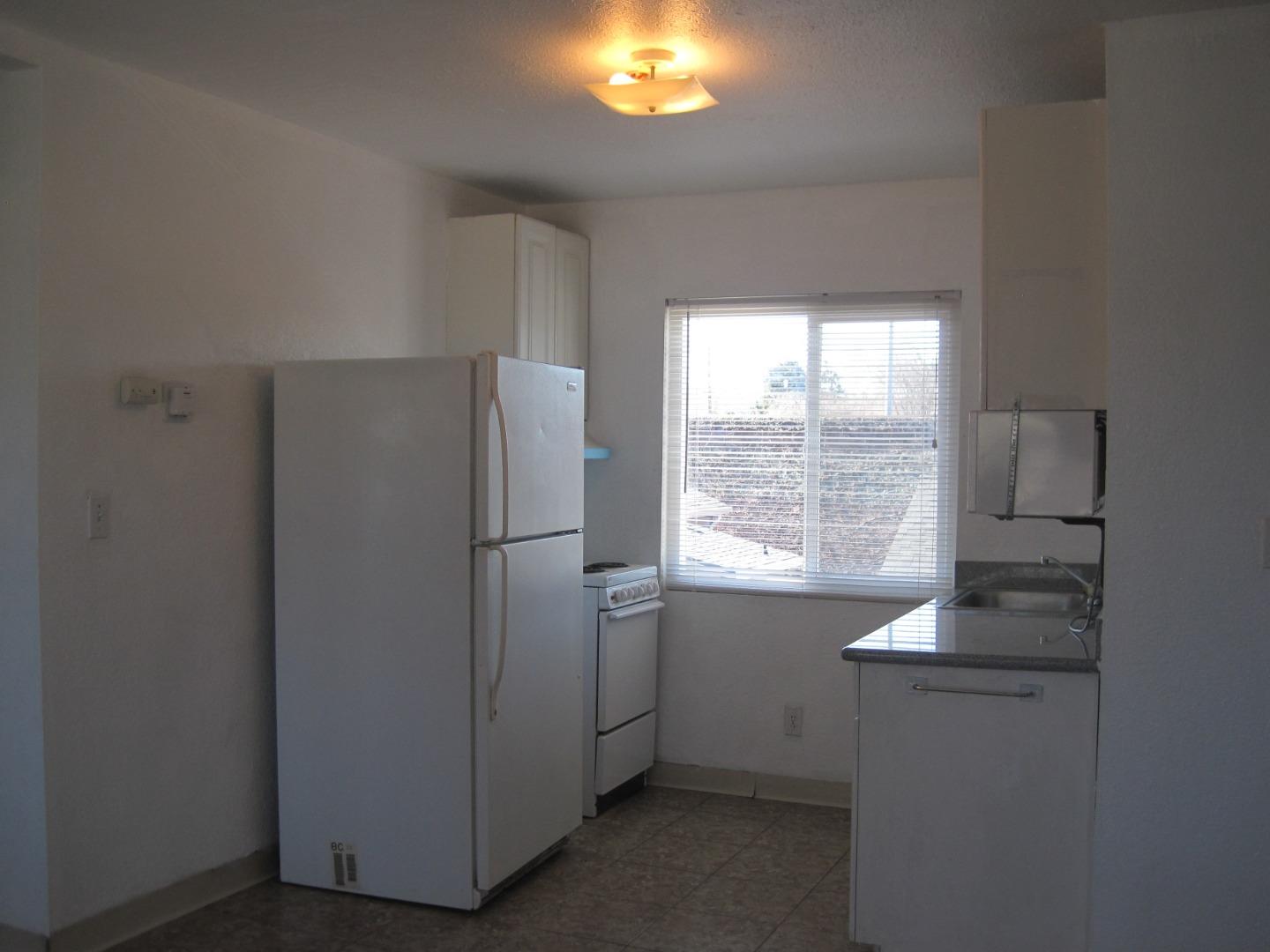 1225 Beacon Avenue San Mateo, CA 94401 - Photo 5 of 21 a room with a window and a refrigerator