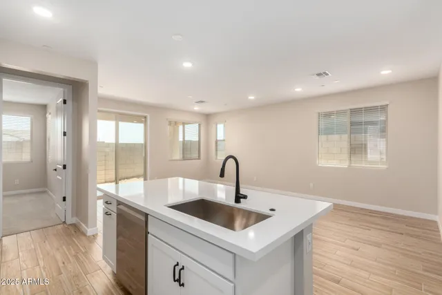 a kitchen with kitchen island a sink appliances and a large window