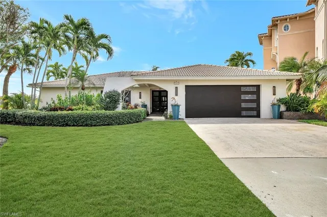 a front view of a house with a yard and potted plants