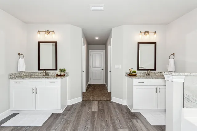 a en suite bathroom with a granite countertop sink and a mirror