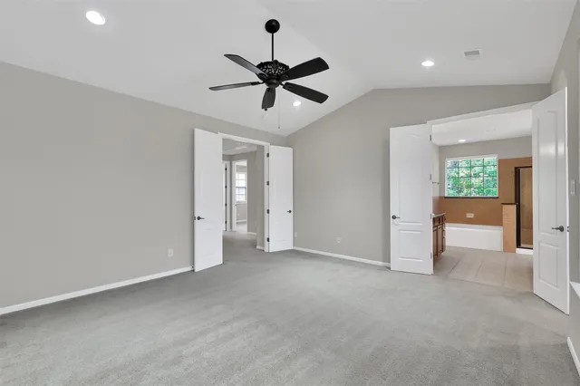 a spacious bathroom with a granite countertop sink a mirror a bathtub and shower