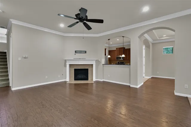a view of an empty room with wooden floor and a fireplace