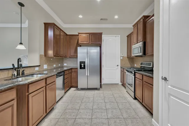 a kitchen with stainless steel appliances granite countertop a refrigerator and a sink