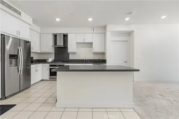 a kitchen with granite countertop white cabinets and appliances