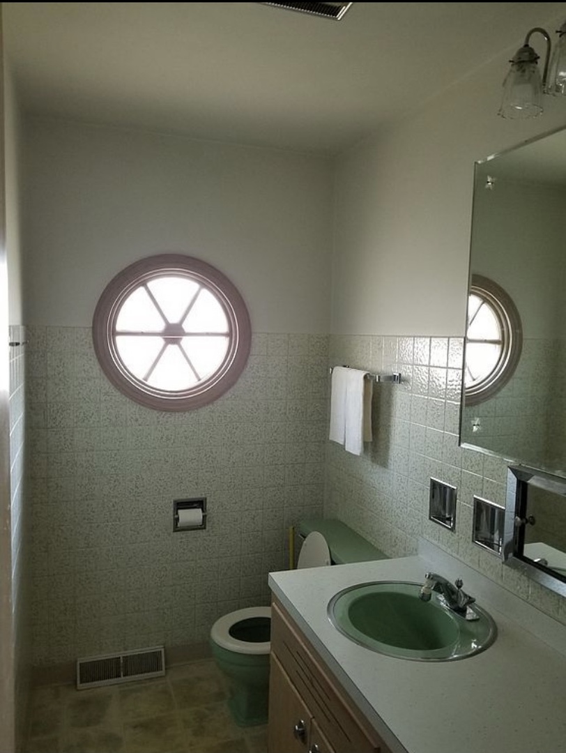8418 Rutherford Avenue Burbank, IL 60459 - Photo 6 of 7 a bathroom with a sink and mirror