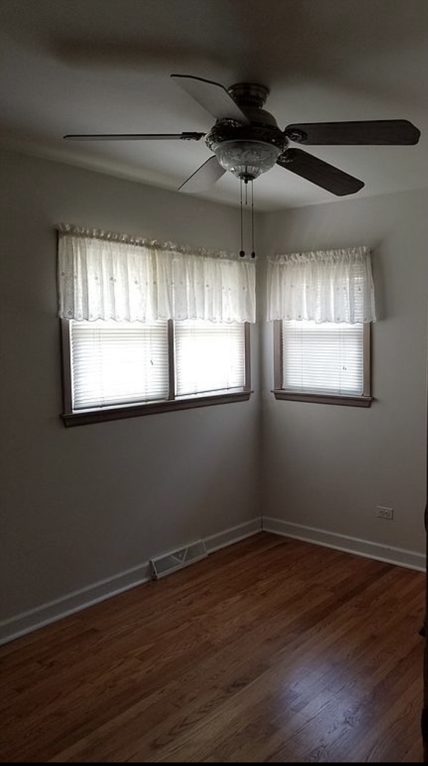 8418 Rutherford Avenue Burbank, IL 60459 - Photo 7 of 7 an empty room with wooden floor and windows