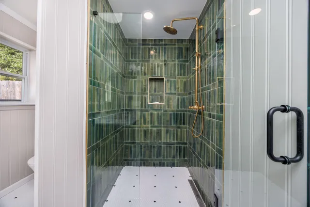 a aerial view of a white house next to a yard with plants and trees