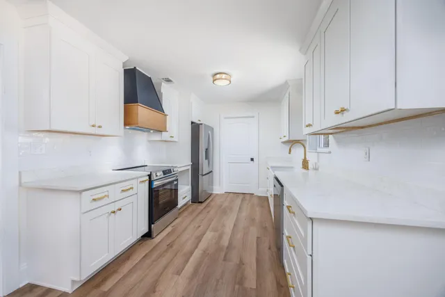 a kitchen with a sink a stove and cabinets