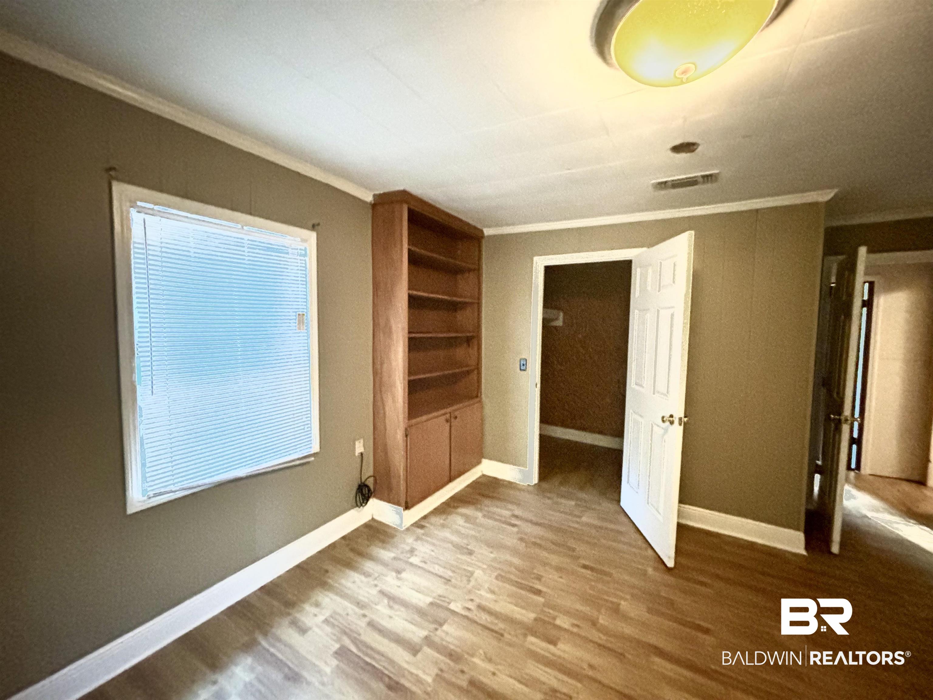 17495 County Road 48 Robertsdale, AL 36567 - Photo 28 of 37 Unfurnished bedroom featuring crown molding and hardwood / wood-style flooring