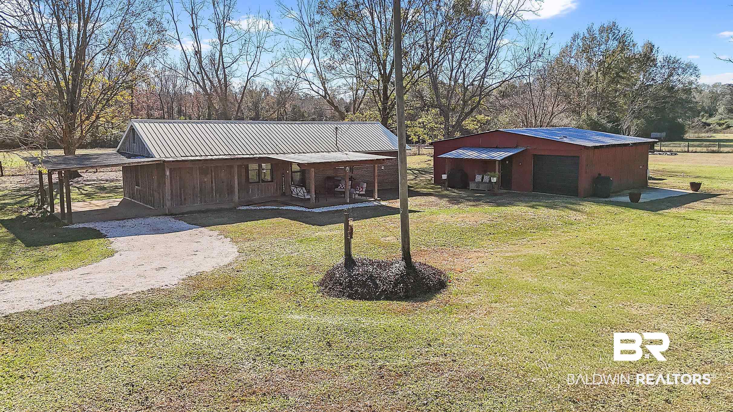110 Sam Jones Road Atmore, AL 36502 - Photo 7 of 47 View of front of house with an outdoor structure, a metal roof, a front lawn, covered porch, and driveway