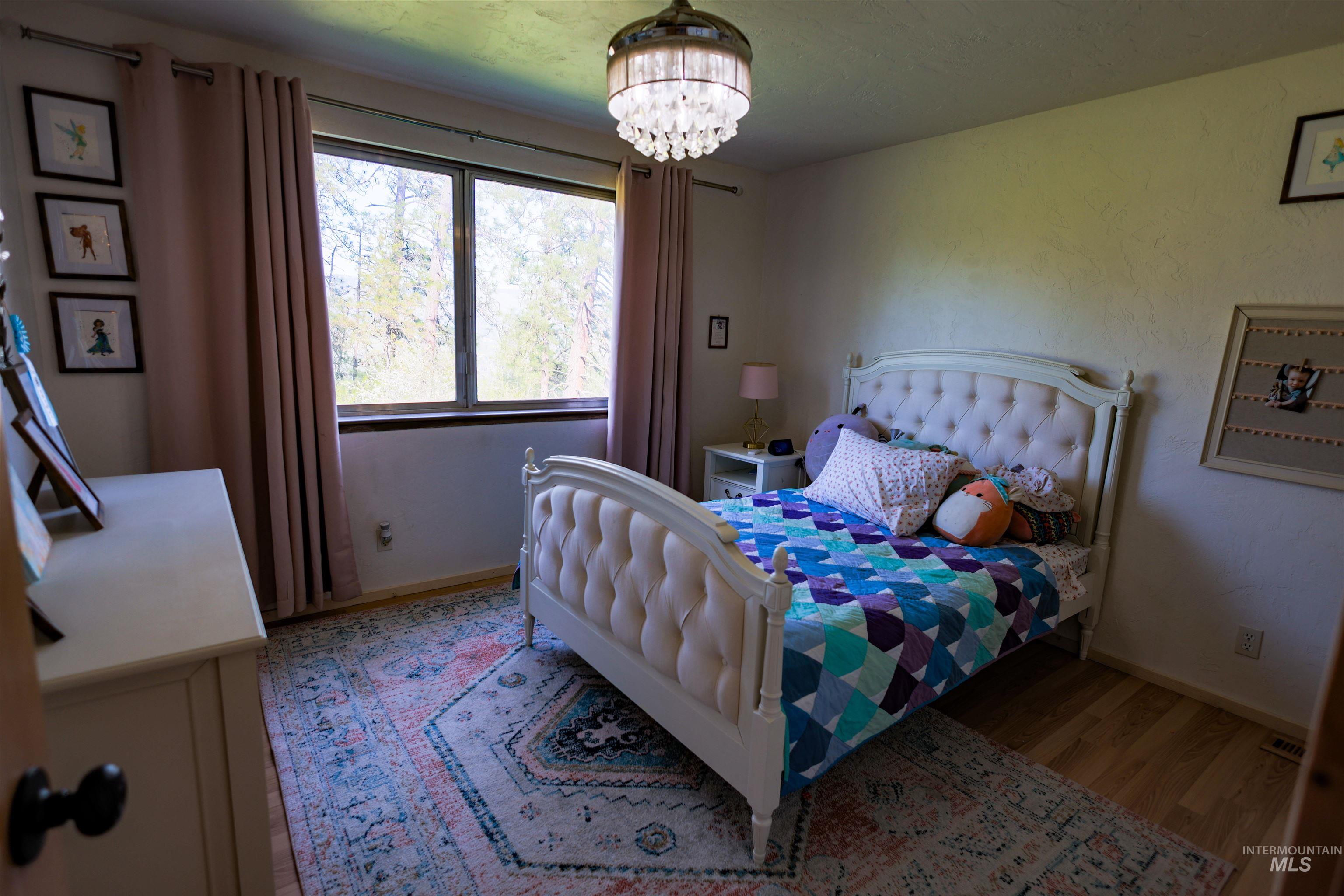 3230 Highway 64 Kamiah, ID 83536 - Photo 40 of 50 Bedroom with wood finished floors and a chandelier