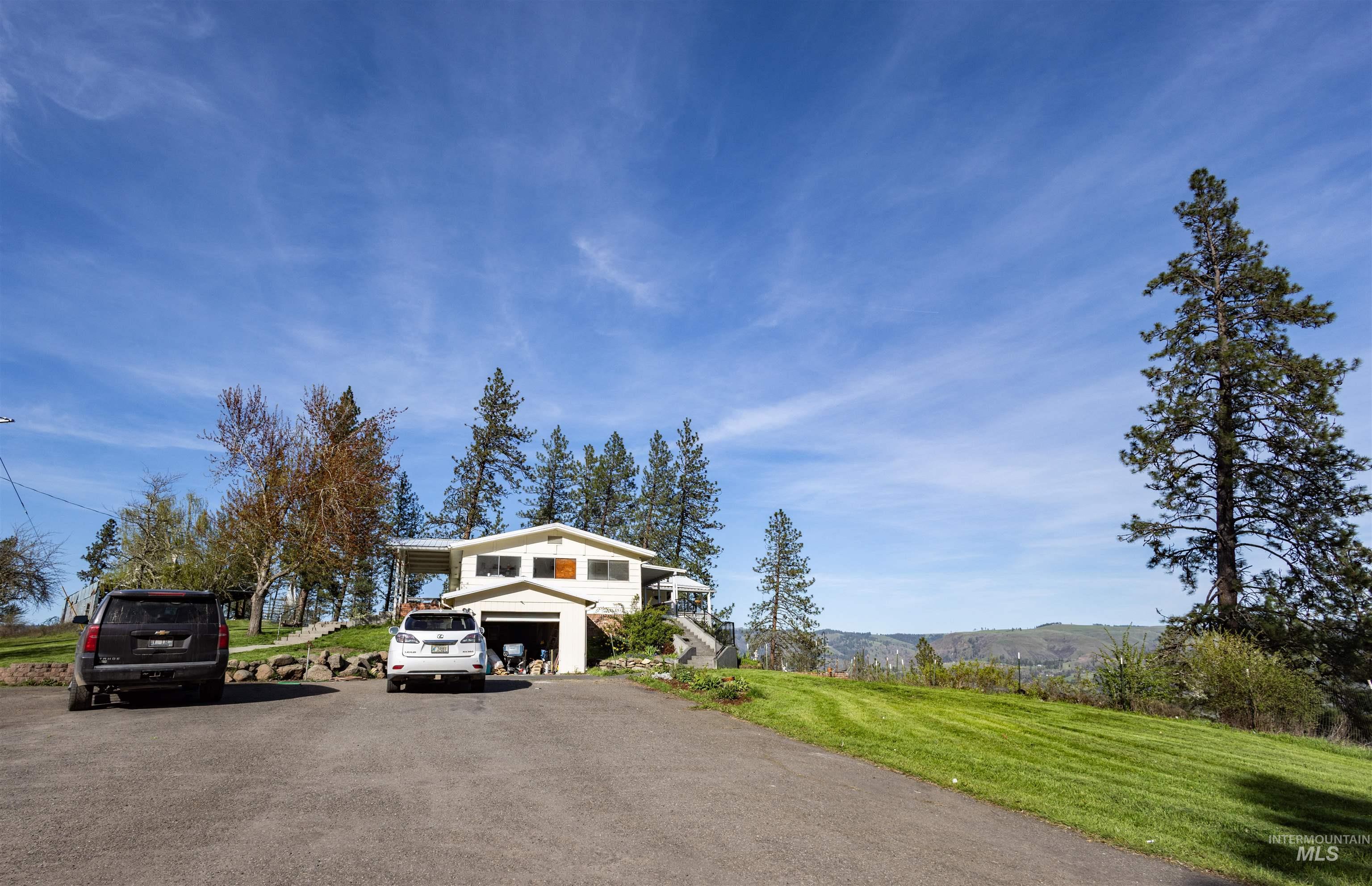 3230 Highway 64 Kamiah, ID 83536 - Photo 5 of 50 View of front of home featuring a front yard, asphalt driveway, a garage, and a mountain view