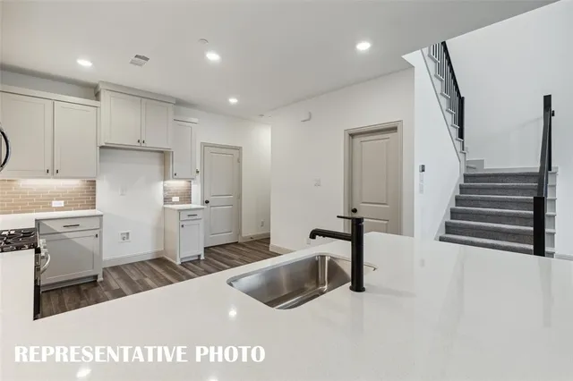 a kitchen with a sink stainless steel appliances and white cabinets