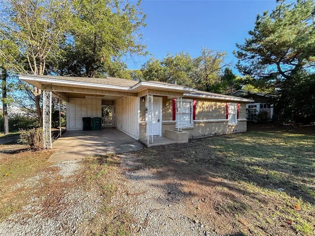 a view of a house with a yard and large tree