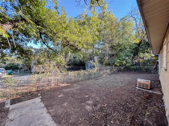 a view of a yard with plants and trees