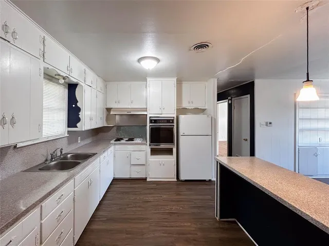 a kitchen with stainless steel appliances a refrigerator sink and cabinets