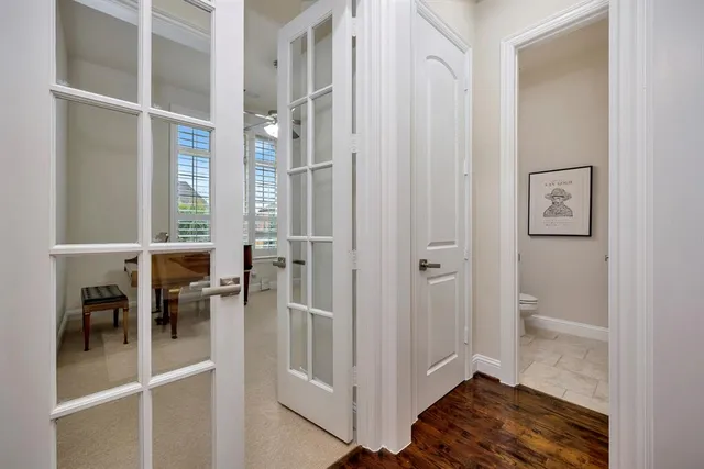 a view of a hallway with wooden floor and dining room