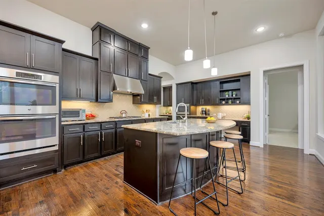 a kitchen with kitchen island granite countertop a sink and cabinets